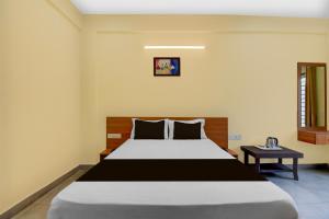 a bedroom with a large bed in a room at Hotel O MYSORE CASTLE in Belagula