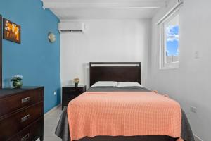 a bedroom with a bed with a orange blanket at Swimming Pool Pet Welcoming Close To The Shore in San Juan +10 photos