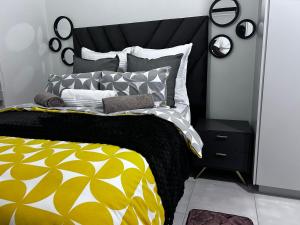 a bedroom with a bed with a yellow and white comforter at The Blyde blue lagoon in Pretoria +29 photos