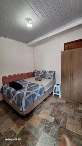 アングラ・ドス・レイスにあるSuíte Angraのベッドと木製のキャビネットのある寝室