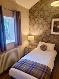 a bedroom with a bed and a window at Kings Arms Hotel in Holme