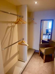 a room with a closet with a chair and a mirror at Kings Arms Hotel in Holme