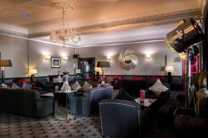 a hotel lobby with couches and tables and a chandelier at Cumberland Hotel - OCEANA COLLECTION in Bournemouth