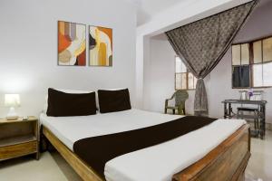 Un dormitorio con cama, escritorio y ventanas en Hotel O Welcome Palace, en Patna 24 fotos más