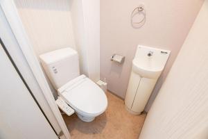 a small bathroom with a toilet and a sink at SPAZIO 6 Hakata Station in Fukuoka
