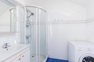 um banheiro com chuveiro e máquina de lavar em Charmante maison au cœur d'Hengoat em Hengoat mais 7 fotografias