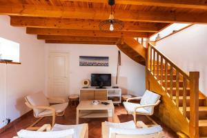 uma sala de estar com uma escada e cadeiras e uma televisão em Charmante maison au cœur d'Hengoat em Hengoat