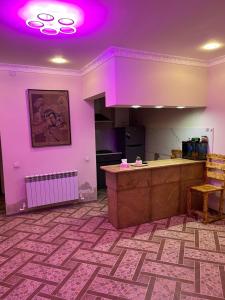 a room with purple lighting and a kitchen with a counter at Ners House in Garni