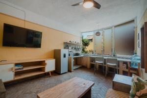 a living room with a television and a dining room at Casa Sayula Home Cerca De Playa y Centro in Sayulita