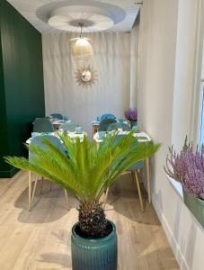 Un comedor con mesas y una planta en maceta. en Best Western Blois Château, en Blois 51 fotos más