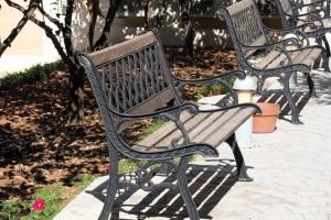 a row of park benches sitting on a sidewalk at Rivotorto Retreat House in Birkirkara