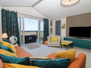 a living room with a couch and a flat screen tv at Sand & Serenity in Norwich