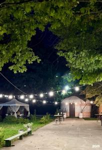 a tent with lights in a park at night at Ethno Adventure Camp Hostel in Almaty +50 photos