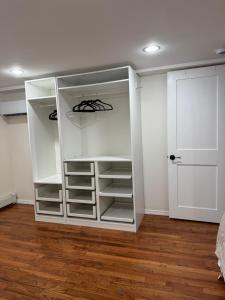 a white closet with white shelves and a door at Calm Retreat in Plainview