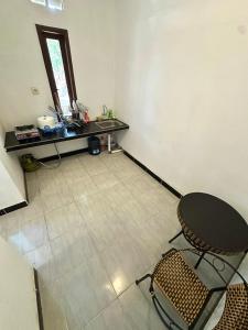una habitación vacía con una mesa y sillas. en Kuta Vibe House, en Kuta Lombok