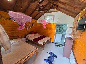 a room with two beds and a tv in it at Dot's bey beach cabanas in Trincomalee