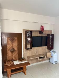 a living room with a tv and a table at Apartamento Centro Lavras in Lavras
