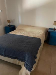 a bed in a room with two night stands and two lamps at Cabaña La Huella in Sierra de la Ventana