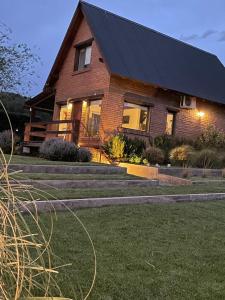 a house with a black roof and stairs at Cabaña La Huella in Sierra de la Ventana