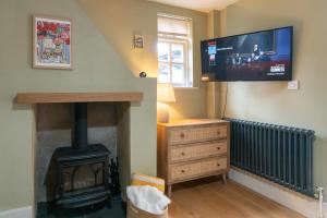 Una sala de estar con chimenea y TV de pantalla plana. en Cosy City-Centre House near Train Station & Business School, with Garden, en Oxford