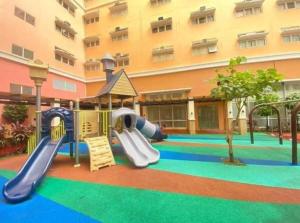 a playground in front of a large building at Miyu's Staycation Place in Biñan
