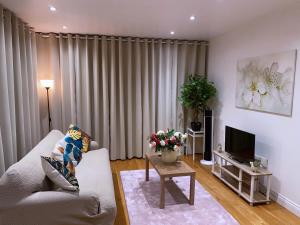 a living room with a couch and a tv at Executive North London Southgate Serviced Apartment - Contractors Ready in East Barnet