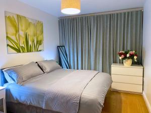 a bedroom with a bed and a window with flowers at Executive North London Southgate Serviced Apartment - Contractors Ready in East Barnet