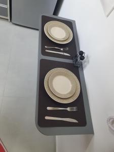 a table with two plates and silverware on it at Full Studio in Santa Maria in Santa Maria