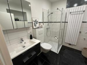 a bathroom with a sink and a shower and a toilet at Ferienwohnung Schwalbennest in Eisfeld