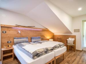 a bedroom with a large bed with a wooden wall at Albergo Panorama in Panchià