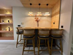 a kitchen with a wooden bar with stools at Centaurus Mall 2BR Xbox Pool, Gym & City View in Islamabad +23 photos