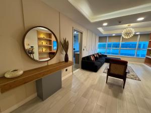 a living room with a mirror and a couch at Centaurus Mall 2BR Xbox Pool, Gym & City View in Islamabad