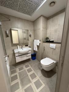 a bathroom with a toilet and a sink at Centaurus Mall 2BR Xbox Pool, Gym & City View in Islamabad