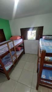 a room with two bunk beds and a window at Casa Hostel da Cida in Pipa