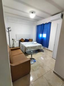 a bedroom with a bed and a couch and a table at Alojamiento de habitaciones Zaidín in Granada
