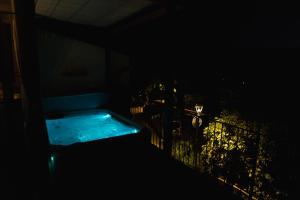 a bath tub in a dark room with a fence at POPPI garden in Poppi