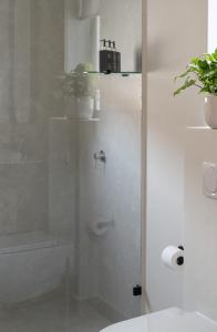 een douche met een glazen deur in een badkamer bij Satori Lodge by Bliss Collection in Kaapstad