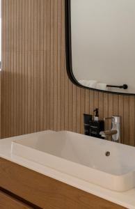 een badkamer met een bad en een spiegel bij Satori Lodge by Bliss Collection in Kaapstad