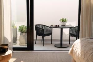 een tafel en stoelen in een kamer met een raam bij Satori Lodge by Bliss Collection in Kaapstad +2 foto's