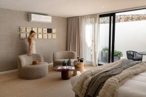 een meisje springt in een slaapkamer met een bed bij Satori Lodge by Bliss Collection in Kaapstad