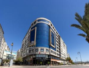 a large blue building on a street with a palm tree at AUREA Hotel in Tétouan