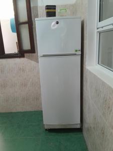 a white refrigerator in a room with a green floor at Casa martil in Martil +1 photo
