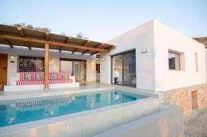 a villa with a swimming pool and a house at FarOut BeachClub - Rooms & Camping in Mylopotas
