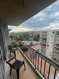 a balcony with two chairs and a view of a pool at Suite Vista Azul Ricaurte in Ricaurte