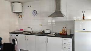 a white kitchen with a sink and a stove at apartamento la carrera in Mondaria +6 photos