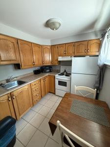 a kitchen with wooden cabinets and a table with a sink at Midstream Manor Unit 3, Studio in St. John's