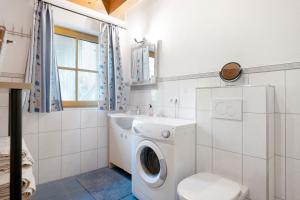 a bathroom with a washing machine and a toilet at Ferienwohnung Brandterhof in Brandenberg +22 photos