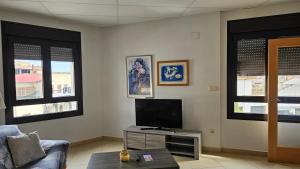 a living room with a tv and some windows at apartamento la carrera in Mondaria