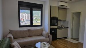 a living room with a couch and a kitchen at LIMONCELLO Apartment in Bar