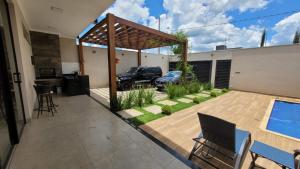 une cour avec une piscine et une pergola dans l'établissement Casa de 3 quartos em Franca - Piscina aquecida, banheira, conforto e lazer, à Franca